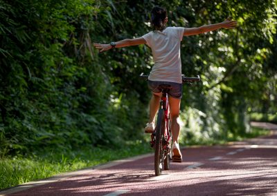 Happy woman riding bike with arms opened